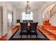 Bright dining room with modern chandelier, statement rug, and doorway to stairwell at 501 River Oaks Ln, Charlotte, NC 28226