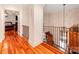 Inviting hallway with wooden floors, a decorative railing, and a glimpse of the chandelier at 501 River Oaks Ln, Charlotte, NC 28226