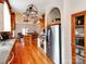 Bright open kitchen featuring a stainless steel refrigerator, wooden floors, and a stylish hanging pot rack at 501 River Oaks Ln, Charlotte, NC 28226