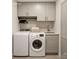 Modern laundry room features front loading washer and dryer, shaker cabinets, and stainless steel sink at 501 River Oaks Ln, Charlotte, NC 28226