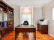 Home office with built-in bookcase, large window, hardwood floors, and neutral walls at 501 River Oaks Ln, Charlotte, NC 28226