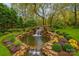 Beautiful backyard featuring a natural stone waterfall flowing into a serene pond surrounded by lush landscaping at 501 River Oaks Ln, Charlotte, NC 28226