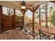 The porch has chairs, a ceiling fan and a view of the backyard with mature trees at 501 River Oaks Ln, Charlotte, NC 28226