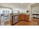 Open-concept kitchen featuring stainless steel dishwasher, wooden cabinets, and eat-in dining area at 20195 Dovekie Ln, Fort Mill, SC 29707