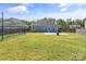 Large backyard with a fire pit, sports netting, and basketball court viewed from the back of the house at 3157 Delaware Dr, Denver, NC 28037