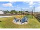 Spacious backyard featuring a fire pit with chairs, sports netting, and a basketball court at 3157 Delaware Dr, Denver, NC 28037
