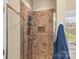 Walk-in shower features tile surround, glass door, shower caddy, and rainfall shower head at 3157 Delaware Dr, Denver, NC 28037