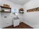 Laundry room with wooden shelves, stainless steel sink, and window at 8508 Tirzah Church Rd, Waxhaw, NC 28173