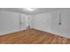 View of basement with laminate flooring, neutral paint, and several doors at 508 Deese St, Monroe, NC 28112