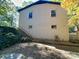 Rear exterior of brick home with a staircase to an elevated entry, surrounded by foliage and trees at 508 Deese St, Monroe, NC 28112