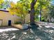 Side exterior of house, with parking pad, foliage, retaining wall and trees at 508 Deese St, Monroe, NC 28112