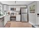Well-lit kitchen featuring stainless steel appliances, white cabinets, and tile flooring at 508 Deese St, Monroe, NC 28112