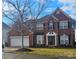 Two-story home with a brick facade, three-car garage, and well-maintained lawn at 13123 Ashley Meadow Dr, Charlotte, NC 28213