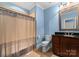 Clean bathroom, featuring dark wood vanity, neutral shower curtain, and granite countertop at 18528 Nantz Rd, Cornelius, NC 28031