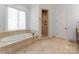 Elegant bathroom with soaking tub, shower, and tile floors at 18528 Nantz Rd, Cornelius, NC 28031