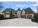 Stunning stone and shingle exterior of a luxurious home with a three-car garage at 18528 Nantz Rd, Cornelius, NC 28031