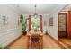 A dining room with natural light, wood floors, and a wooden table with seating underneath a decorative light fixture at 7029 Pebble Bay Dr, Denver, NC 28037