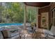 Covered brick patio with view of the backyard pool and wooded area at 7029 Pebble Bay Dr, Denver, NC 28037