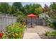 Brick patio area with outdoor dining table and chairs featuring beautiful landscaping and an orange umbrella at 796 Cornelius Rd, Mooresville, NC 28117