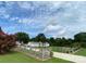 Long private driveway leading to a beautiful white home surrounded by lush greenery under a cloudy sky at 796 Cornelius Rd, Mooresville, NC 28117