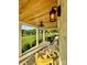 Covered front porch with wooden plank ceiling, overhead fan and yellow chairs overlooking a green lawn at 796 Cornelius Rd, Mooresville, NC 28117