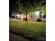 Night view of a detached garage featuring an illuminated white facade and manicured landscaping at 796 Cornelius Rd, Mooresville, NC 28117