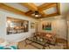 Cozy living room with wooden ceiling beams, a tan leather sofa, and a view into the kitchen at 796 Cornelius Rd, Mooresville, NC 28117