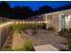 Inviting brick patio with outdoor dining set, grill, fence with lights, and landscape, ideal for relaxation at 796 Cornelius Rd, Mooresville, NC 28117