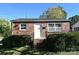 Charming brick home with lush landscaping, stairs to door and black metal railing at 125 S Ervin Ave, Newton, NC 28658
