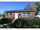 View of a brick home with black metal railing, manicured bushes, and a well-kept lawn at 125 S Ervin Ave, Newton, NC 28658