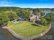 Aerial view of a well-manicured lawn that extends to the waterfront with a private dock and seating at 18212 Pompano Pl, Cornelius, NC 28031