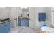 Bright bathroom with double vanity, blue cabinets, marble floors, and ample storage at 18212 Pompano Pl, Cornelius, NC 28031