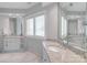 A primary bathroom boasts a double sink vanity with granite countertops and a large mirror at 18212 Pompano Pl, Cornelius, NC 28031