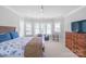 A spacious bedroom is filled with lots of natural light, a sitting area, and a flat screen television at 18212 Pompano Pl, Cornelius, NC 28031