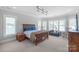 A spacious bedroom is filled with lots of natural light, a sitting area, and wood furnishings at 18212 Pompano Pl, Cornelius, NC 28031