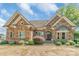 Elegant stone home featuring manicured landscaping, a paved driveway, and inviting entryway at 18212 Pompano Pl, Cornelius, NC 28031