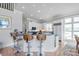 An open kitchen features a central island with barstool seating and white cabinets and stainless steel appliances at 18212 Pompano Pl, Cornelius, NC 28031