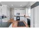 This kitchen offers white cabinets, black appliances, and butcher block countertops with backsplash at 18212 Pompano Pl, Cornelius, NC 28031