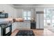 A bright kitchen featuring modern stainless steel appliances, white cabinets, and wood floors at 18212 Pompano Pl, Cornelius, NC 28031