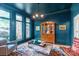 Blue living room with large windows, hardwood floors, and display cabinet at 18212 Pompano Pl, Cornelius, NC 28031