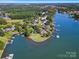 Scenic waterfront view featuring grassy shoreline, stone embankment, and tranquil water views at 18212 Pompano Pl, Cornelius, NC 28031