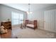 Cozy bedroom showcasing a rocking chair, crib, and ample natural light from a window at 5039 Penn Rd, Iron Station, NC 28080