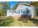 A light blue house is pictured with bright blue shutters with a well maintained lawn at 5039 Penn Rd, Iron Station, NC 28080