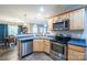 Well-lit kitchen with stainless steel appliances, wooden cabinets, and open access to the dining area at 5039 Penn Rd, Iron Station, NC 28080