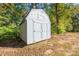 A detached shed in a wooded area featuring double doors and a gable roof at 5039 Penn Rd, Iron Station, NC 28080