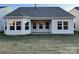 View of the house's backyard featuring a covered patio with multiple windows and dormant grass at 1032 Bull Dog Ln, Wingate, NC 28174