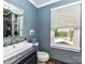 Bathroom with vanity, toilet, window, and blue walls at 316 Carter Rd, Monroe, NC 28110