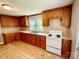 Simple kitchen with wood cabinets and white appliances at 503 Broad St, Kings Mountain, NC 28086