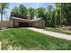 House exterior with stone and wood siding, two-car garage, and a grassy yard at 315 Camelot Dr, Salisbury, NC 28144