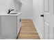 Laundry room with white cabinets, sink, and hardwood style flooring at 3503 Linwood Rd, Gastonia, NC 28052